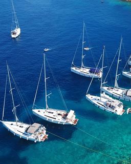 Multiple sail boats moored with shore-lines