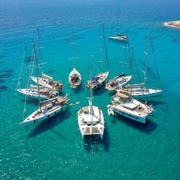 Stunning Aerial View of Sailing Boats in Turquoise Tropical Bay Arranged in a Star Formation